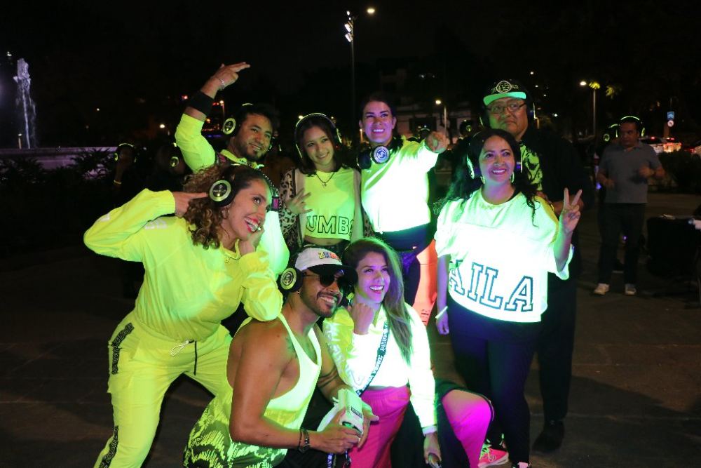Grupo bailando con audífonos verdes en Silent Neon Party
