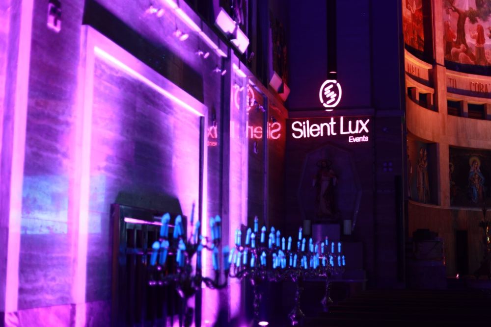 Fachada de Silent Lux Events iluminada en violeta