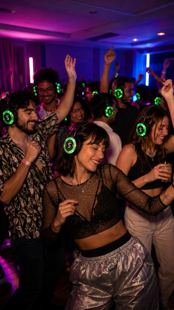 Multitud bailando entre luces de neón